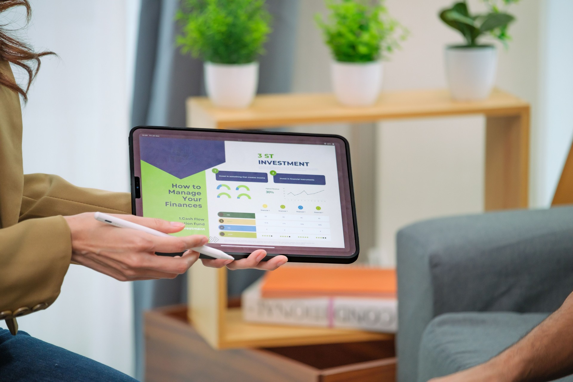 asian financial advisor presenting charts and data on a tablet during couple client meeting.financial planning and decision-making